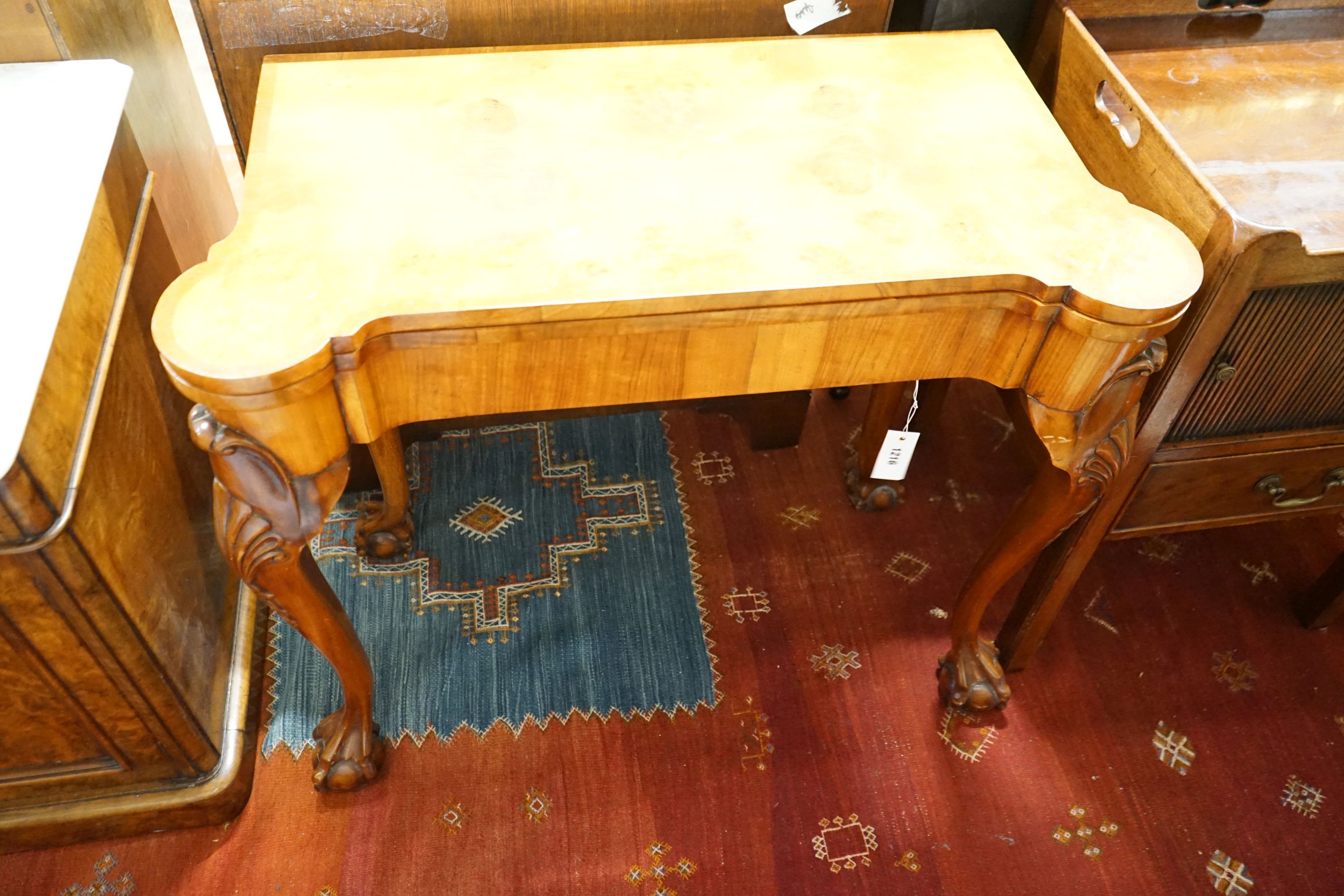 A Queen Anne revival burr walnut card table, with a red leather interior, length 86cm, depth 43cm, height 74cm